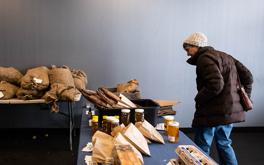A woman walks through a winter market hosted by FAHNN on Syracuse's Southside. (Emily Kenny/Spectrum News 1)